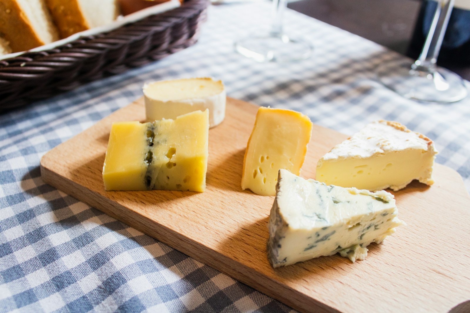 Cachorro Pode Comer Queijo? Descubra a Quantidade Segura e os Riscos que Poucos Tutores Conhecem Cachorro pode comer queijo: variedade de queijos dispostos sobre tábua de madeira