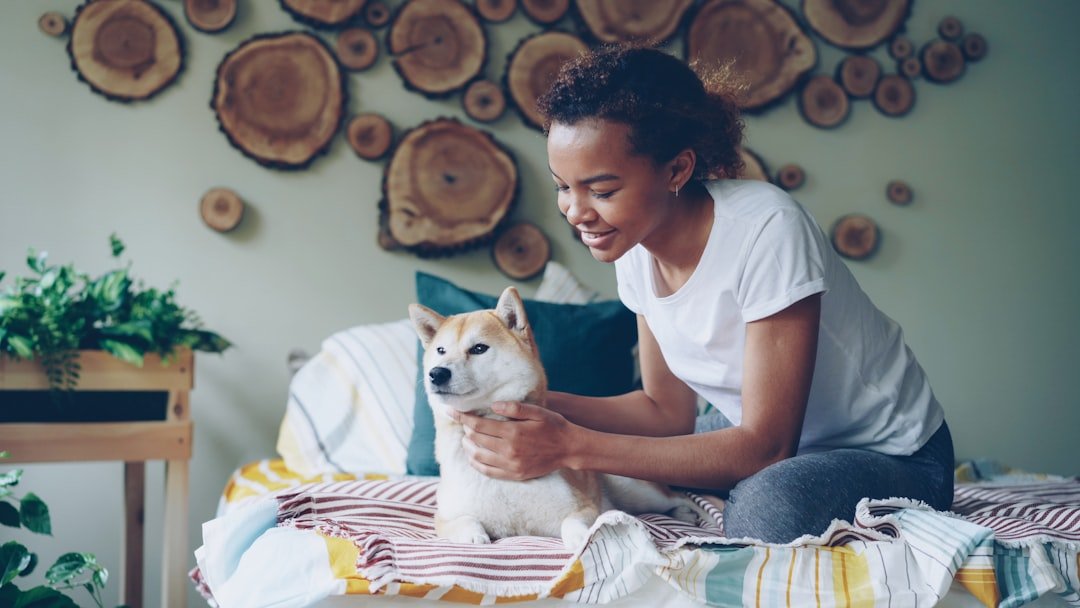 Cachorro sente quando alguém vai morrer: tutora fazendo carinho no cão deitado na cama