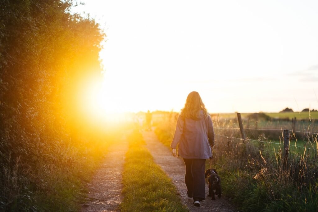 Reencarnação de cachorro: tutora caminhando com o cão ao entardecer