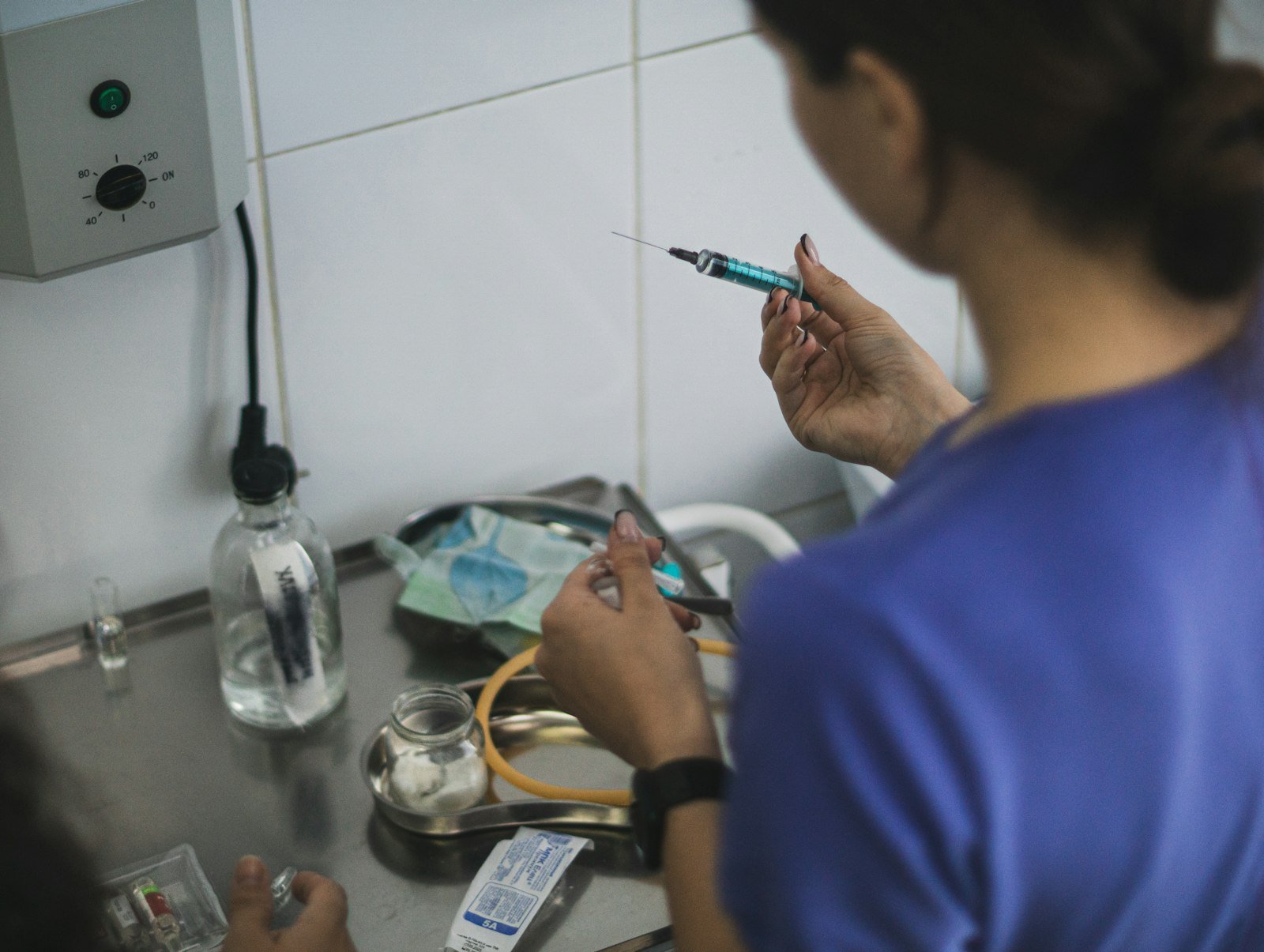 Vitamina B12 para cachorro: profissional preparando uma seringa para aplicação de medicamento injetável