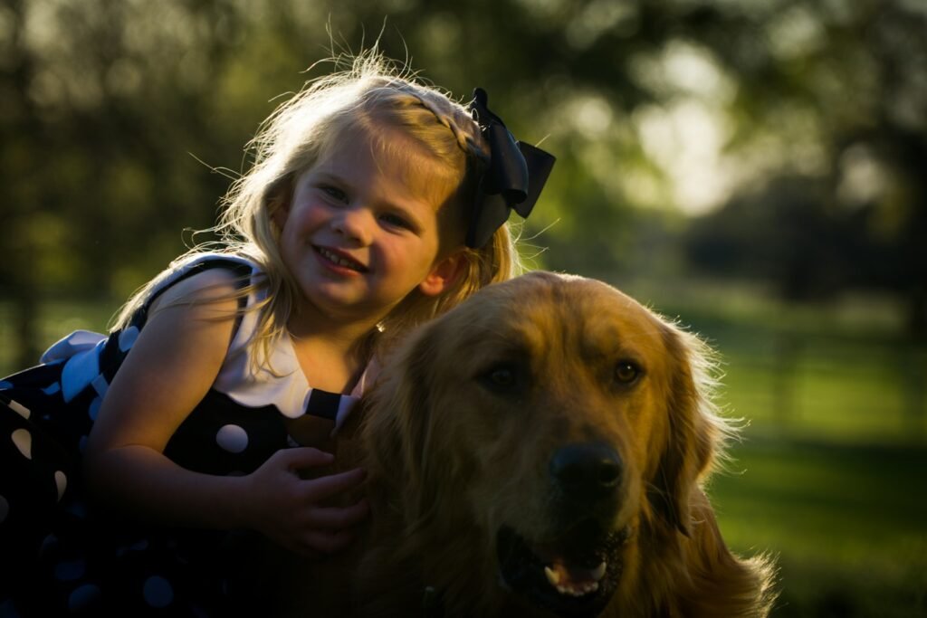 Cachorro para criança autista sorridente abraçando golden retriever ao entardecer