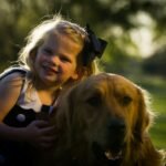Cachorro para criança autista sorridente abraçando golden retriever ao entardecer