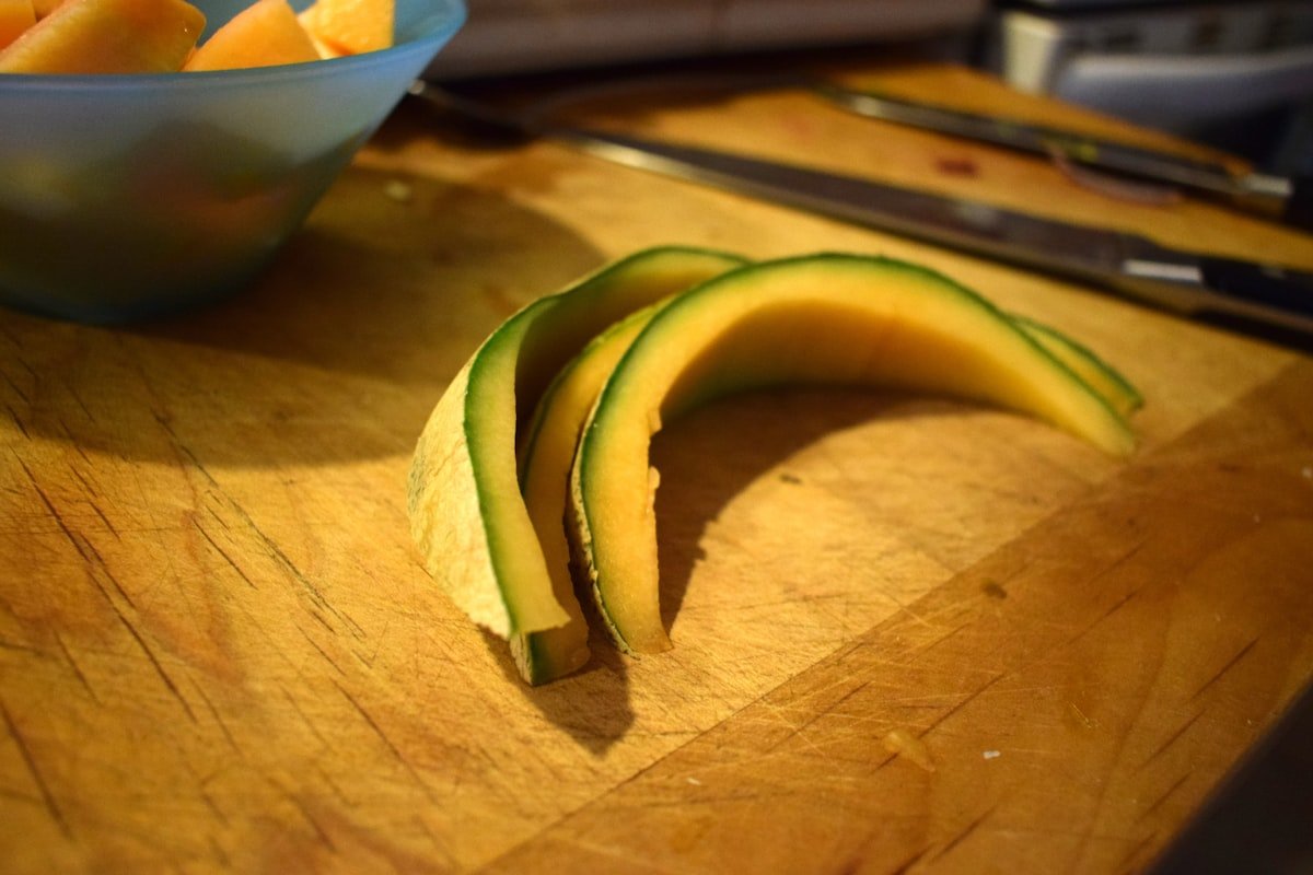 Cachorro Pode Comer Melão? Guia Completo Para Oferecer com Segurança Cachorro pode comer melão como uma das opções de frutas seguras, ilustradas aqui em fatias sobre uma tábua de madeira