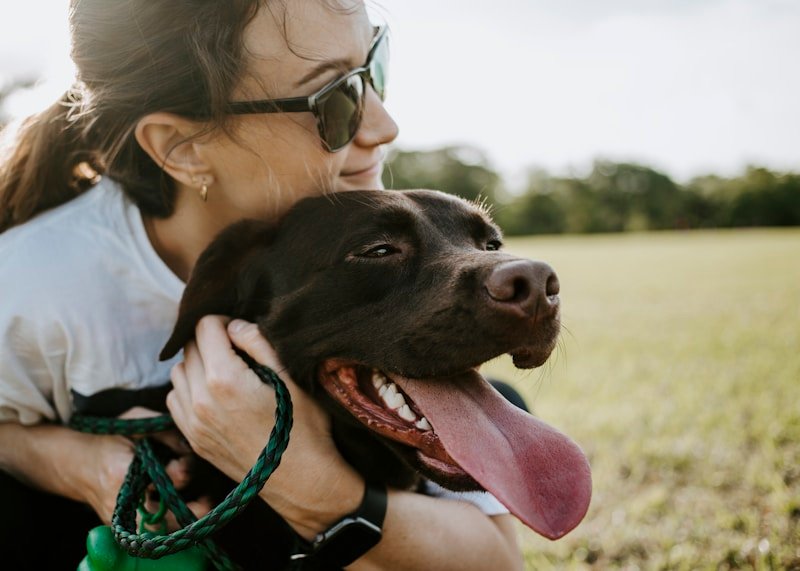 Cachorro com síndrome de down: tutora abraçando com carinho um cão de pelagem escura