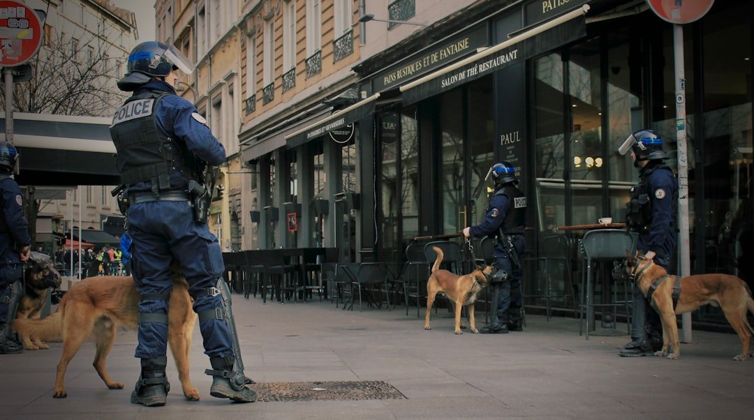 Cão policial patrulhando ao lado de policiais fardados em via pública