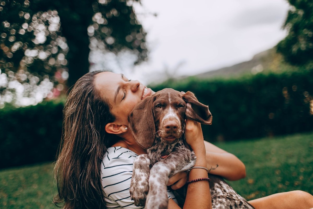 Cuidados paliativos para cachorro: tutora abraçando o cão com carinho no colo