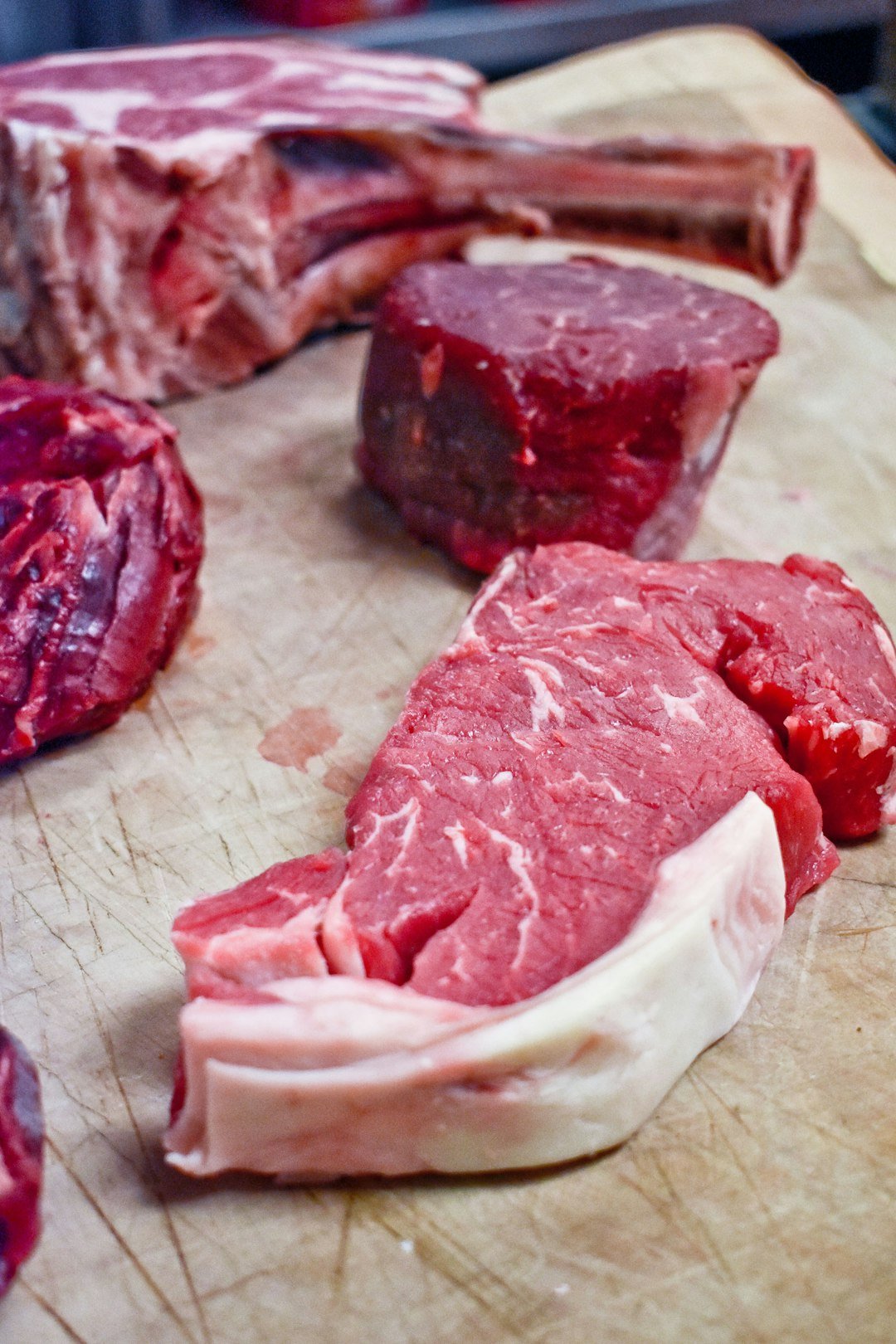 Osso cozido para cachorro: pedaço de carne crua com osso sobre tábua de corte