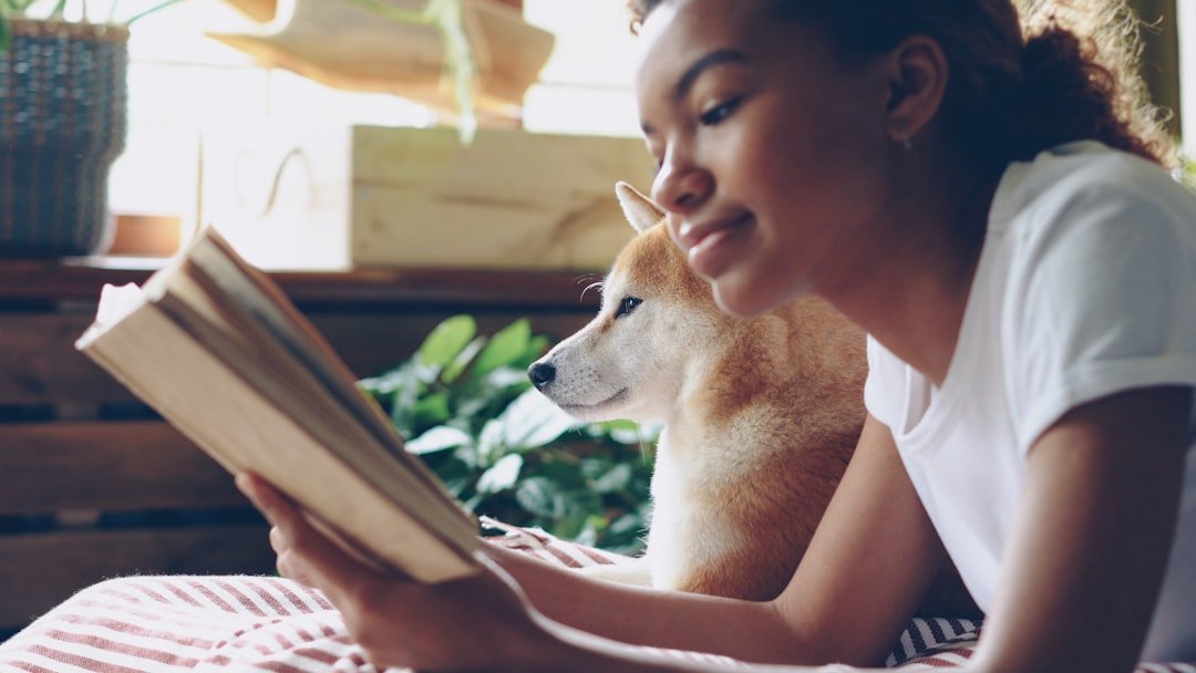 Signo do cachorro: tutora lendo um livro ao lado do cão, simbolizando o equilíbrio entre ciência e intuição