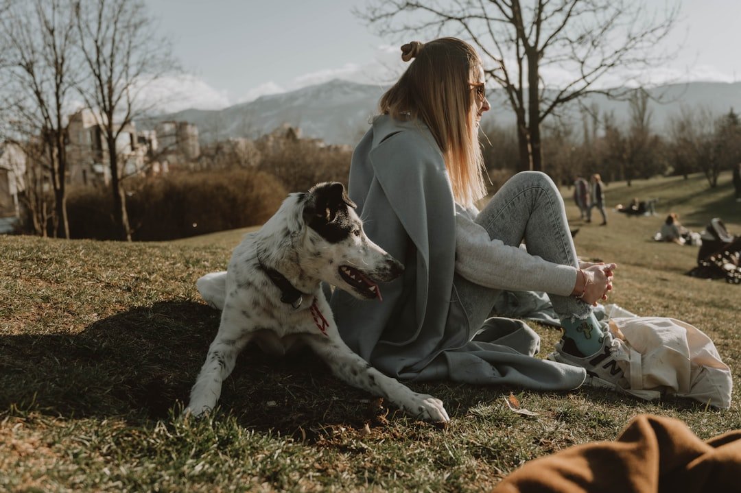 Signo do cachorro: tutora sentada no gramado ao lado do cão, reforçando o vínculo observado na leitura astrológica